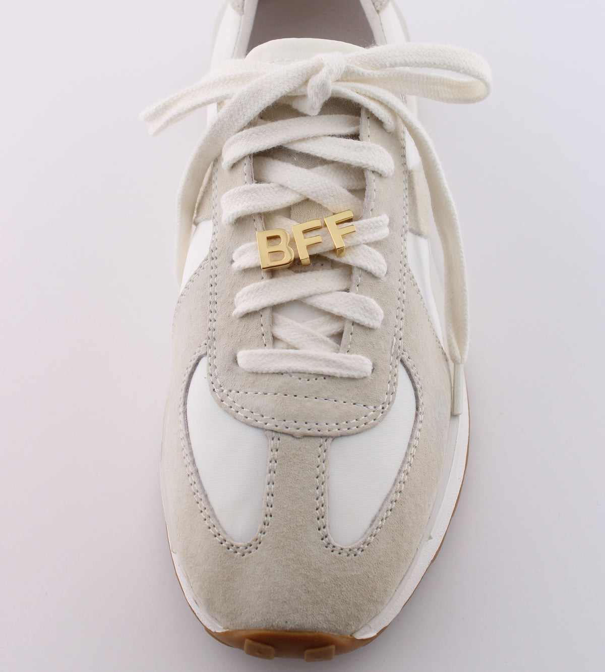 White sneaker with 'BFF' charm on a light gray background