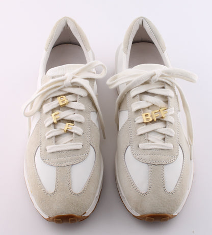 Pair of white sneakers with gold BFF letter charm set on shoelaces - best friends personalized sneaker charms