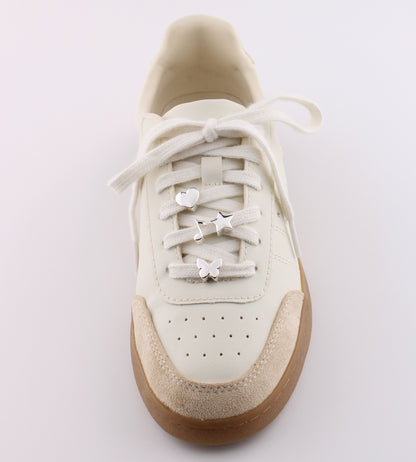 White sneaker with silver emoji charms heart star lightning and butterfly on white shoelaces - silver emoji sneaker charms